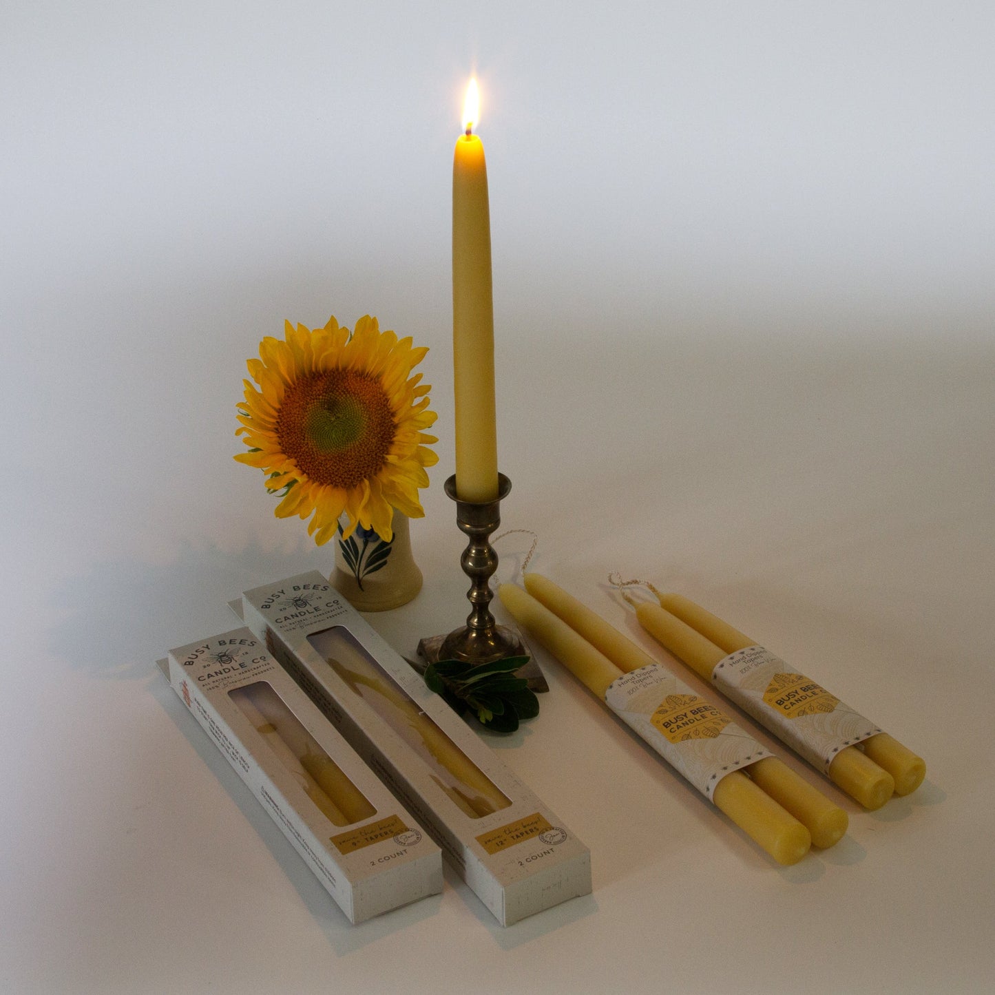 Lit taper candle with different sized taper candles laying around it
