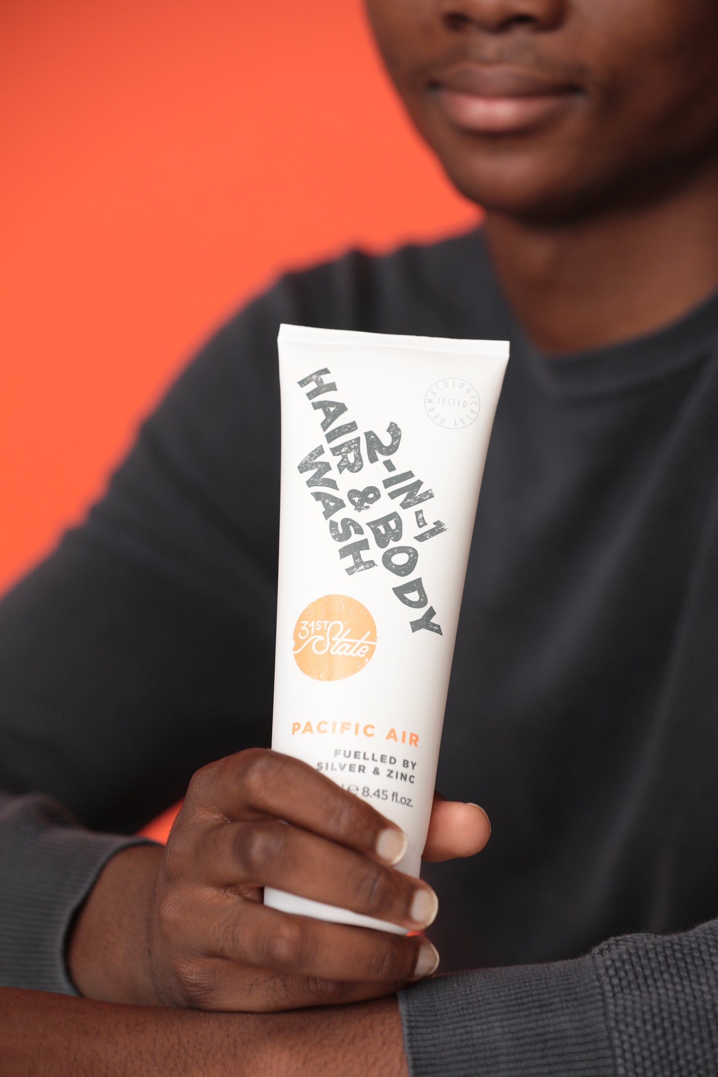 Teen boy holding 31st State 2-in-1 Hair and Body Wash Tube